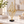 Gold diamond-shaped metal sculpture with clear orb and black base on a console