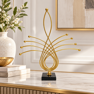 Gold abstract metal sculpture displayed on an entryway console